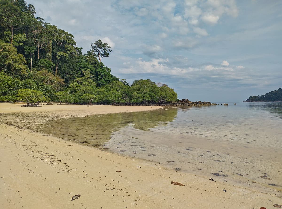 A quiet sandy bay backed by rainforest on North Surin Island