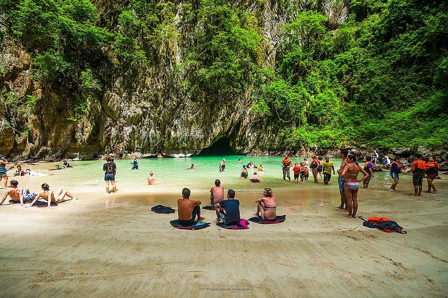 Swimmers on the hidden beach inside the Emerald Cave on Koh Mook