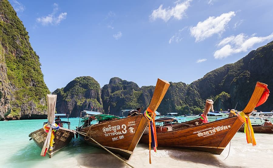 Longtail boats beneath the cliffs of Maya Bay, photographed before boats were barred from the beach