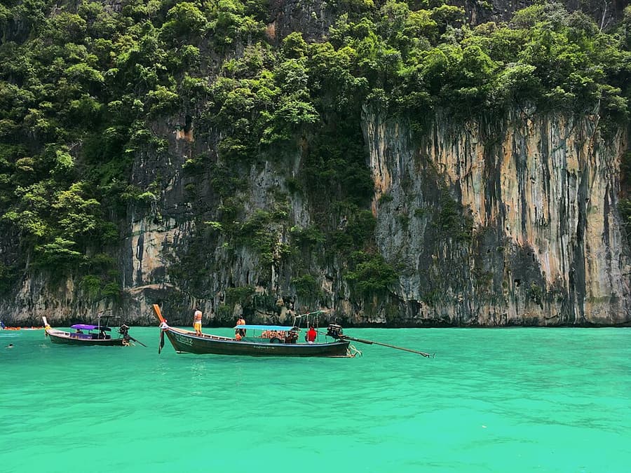 A longtail boat on the green water of Pileh Lagoon, Phi Phi Leh